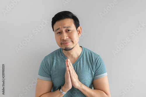 Foto Man is begging for something on grey background.