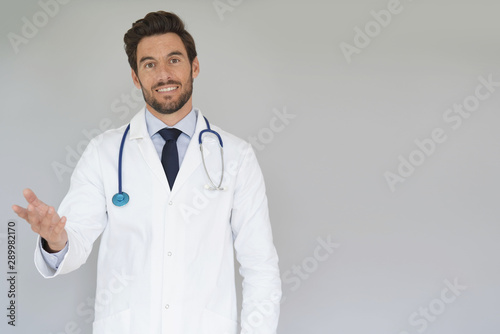 Smiling doctor standing on grey background