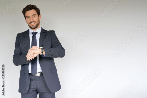 Businessman on white background, checking time