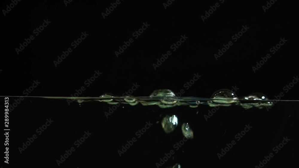 Air bubbles beautifully float to the surface of the water on a black background, splash screen, time lapse, close-up Air bubbles beautifully float to the surface of the water on a black background, splash screen, time lapse, close-up