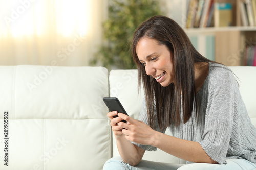 Happy woman at home using a smart phone