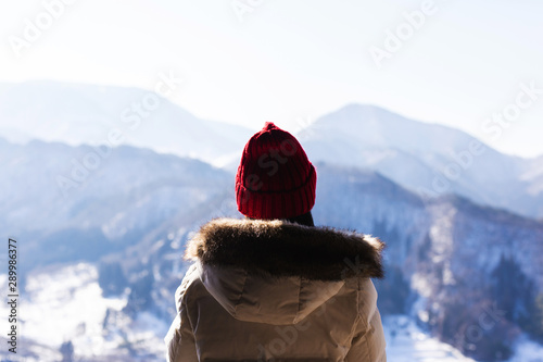 Young woman looking at an mountain in a white haze with sunlight winter in Japan photo