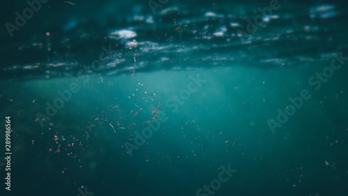 microplastics floating in ocean water, micro plastic pollution photo
