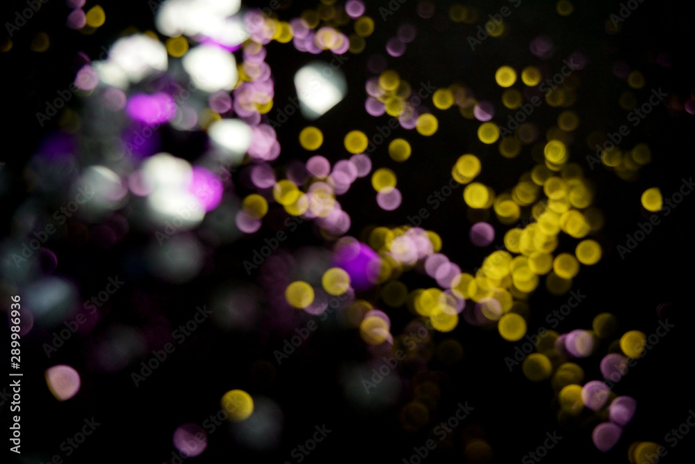 Yellow and violet bokeh lights. Christmas background.