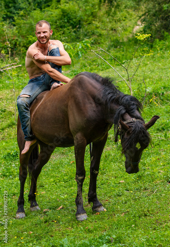 man with a naked torso riding horse