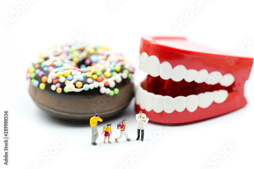 Miniature people : Doctor dentist speaks about student and children with desserts,Fun eating and healthcare concept.