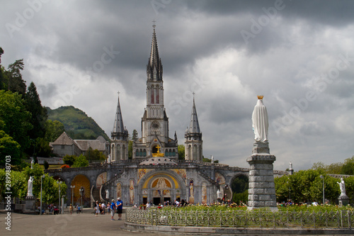 Basilica of the Immaculate Conception in Lourdes, France, under dark clouds
