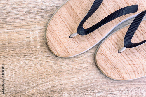 Close up sandal on the wooden background. Top view of wooden flip flops with copy space. Flat lay. Summer holiday concept.