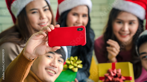 Background of Teenagers  both men  and women  organize New Year s events  take pictures with mobile phones and give gifts. Drink happily Help each other decorate the Christmas tree. 