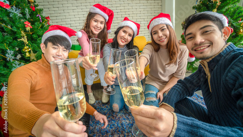Background of Teenagers, both men, and women, organize New Year's events, take pictures with mobile phones and give gifts. Drink happily Help each other decorate the Christmas tree. 