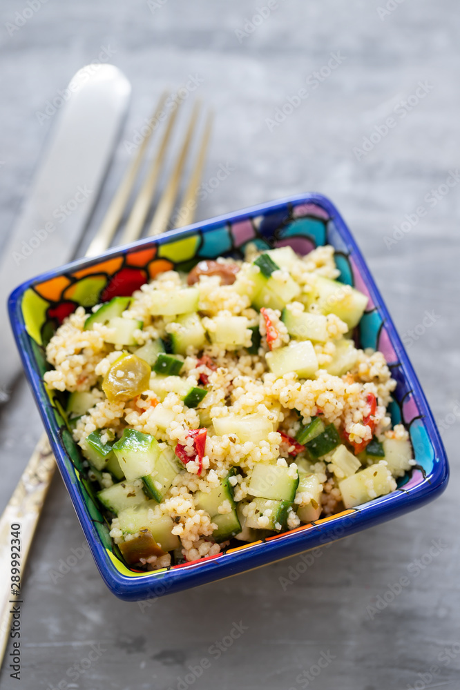 tabbouleh in small bowl on ceramic background tabbouleh in small bowl on ceramic background