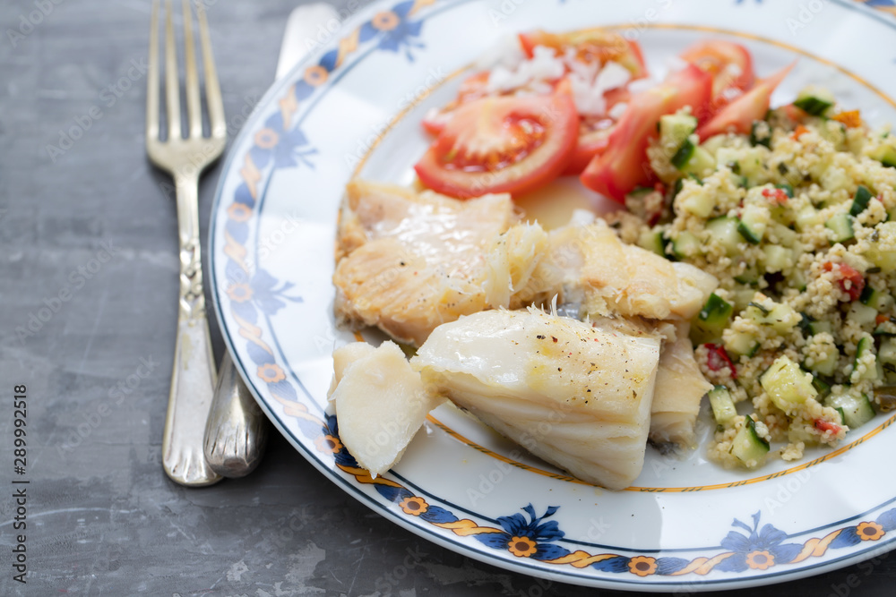 cod fish with quinoa and fresh salad on dish