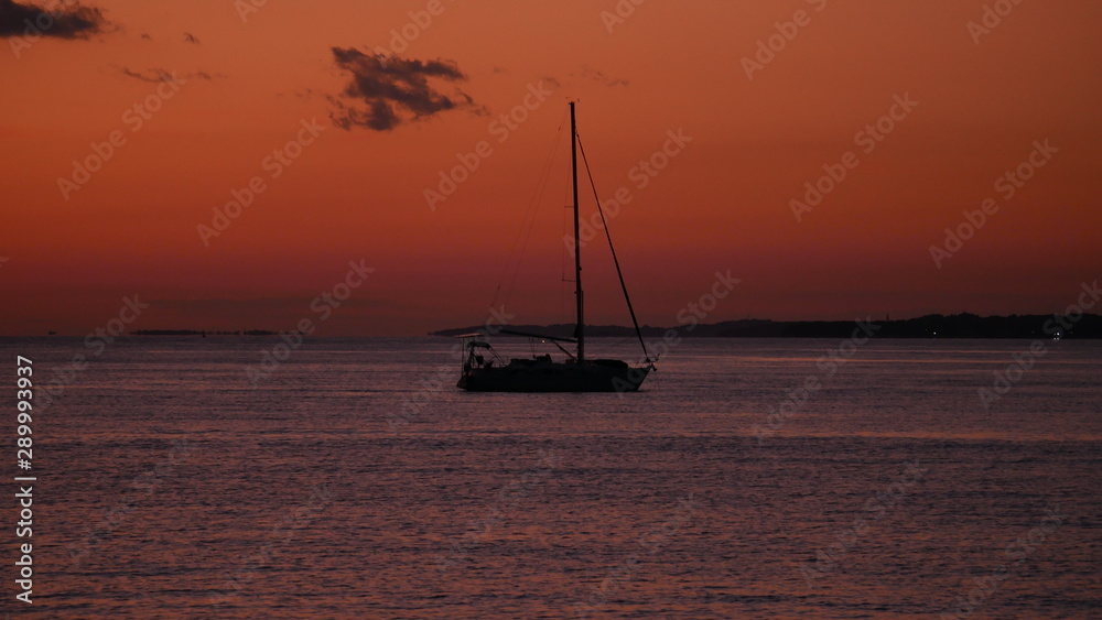 Fazana, Kroatien: Segelboot liegt bei Sonnenuntergang vor der istrischen Küste