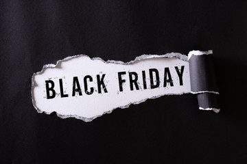Top view of Black torn paper and the text black friday on a white background. Black Friday composition.