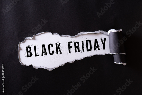 Top view of Black torn paper and the text black friday on a white background. Black Friday composition.