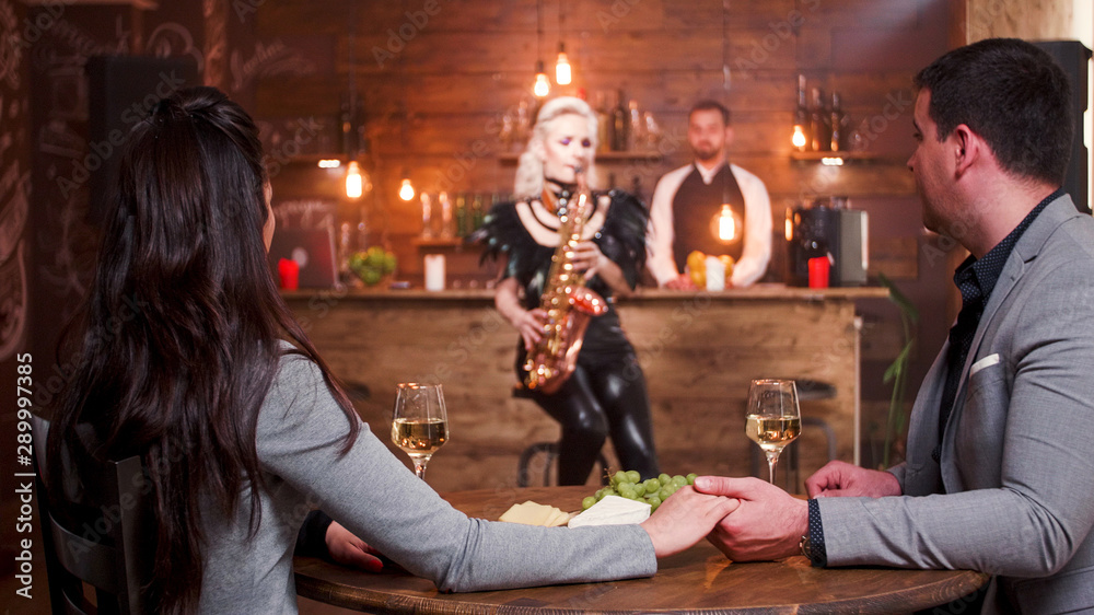 Woman in a jazz pub performing a jazz song on her saxophone
