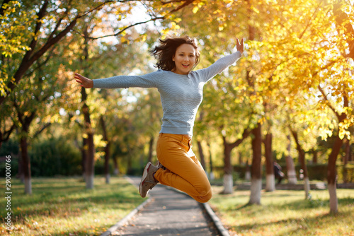 season and people concept. happy girl jumping at autumn park