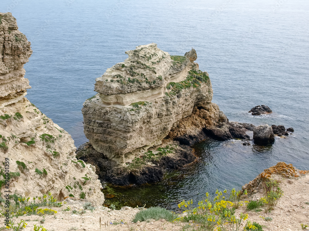 Solitary limestone rock in water near the sea coast