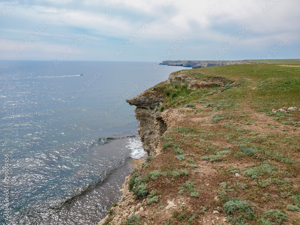 Sea coast with steep textured limestone rocks and distant horizon