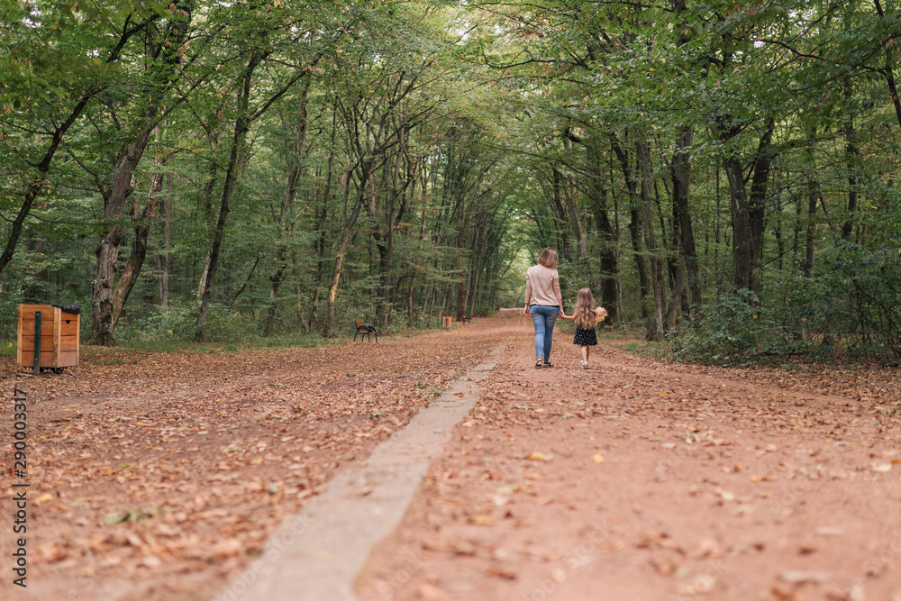 pregnant woman and daughter walking in forest