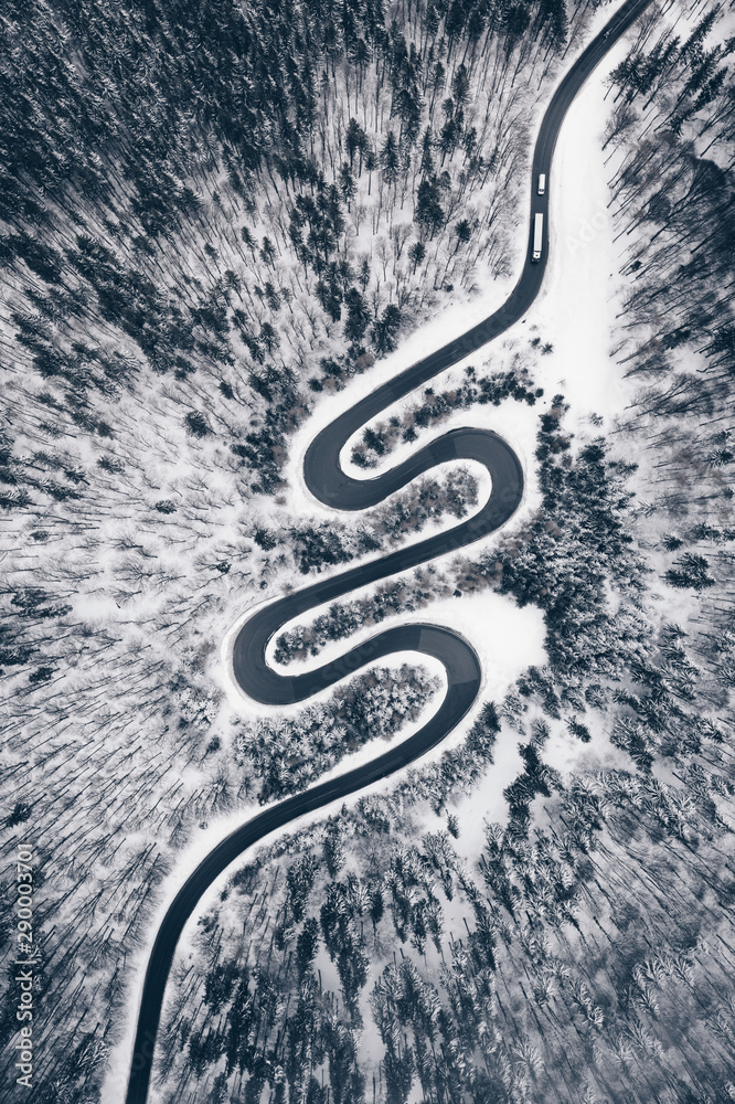Top down view of a road in the middle of the forest in winter season