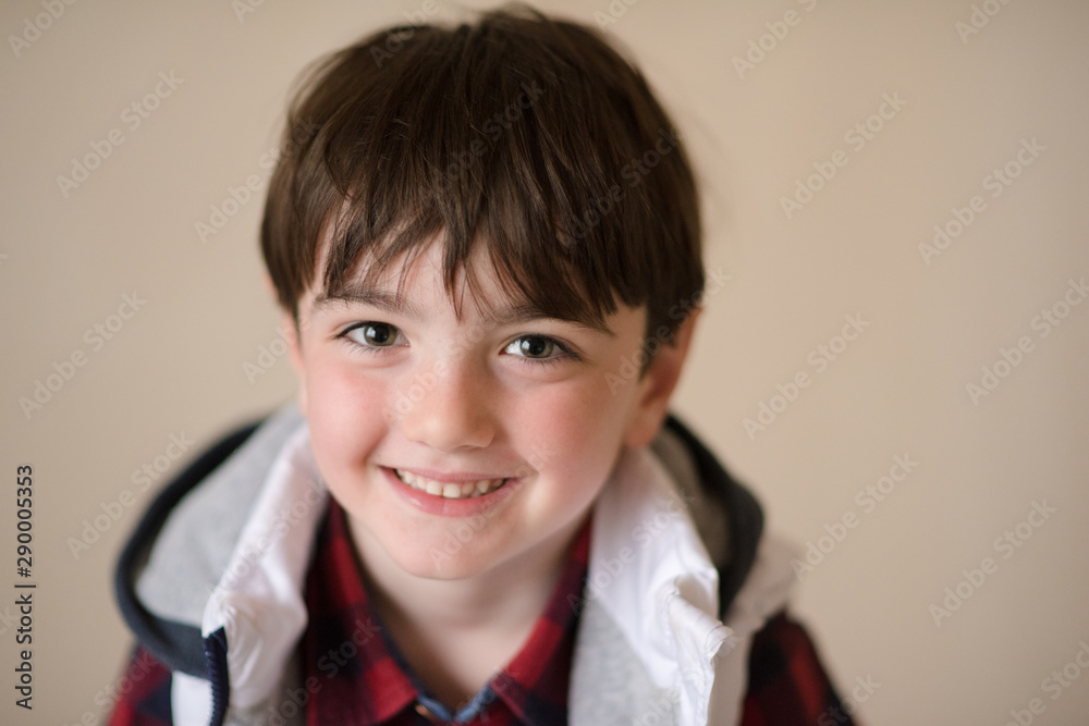 portrait of handsome happy smiling little kid wearing red plaid shirt and sleeveless hoodie jacket in cold weather season portrait of handsome happy smiling little kid wearing red plaid shirt and sleeveless hoodie jacket in cold weather season