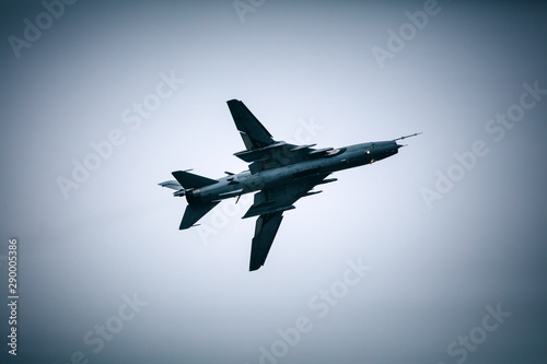 Military jet fighter flying in the cloudy sky