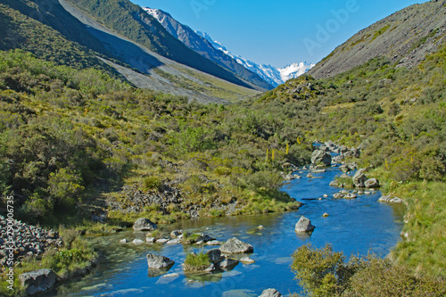 Snow capped mountains backdrop to valley stream