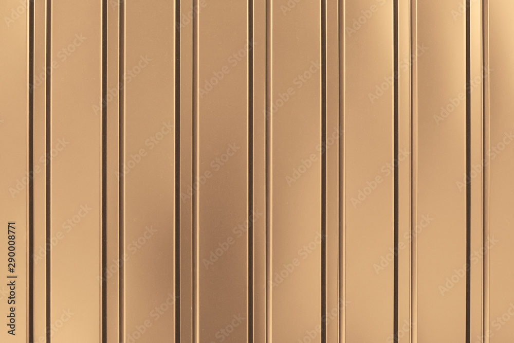 Gold background of metal wall siding, cladding. Fence with shiny