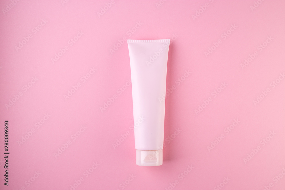 Plastic tube with face or body cream on pastel pink background Plastic tube with face or body cream on pastel pink background