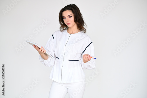 Concept photo portrait of a cute pretty beautiful brunette girl with excellent makeup in white clothes with a folder in her hands on a white background. In different poses with emotions.