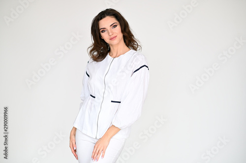 Concept photo portrait of a cute pretty beautiful brunette girl with great makeup in white clothes on a white background. In different poses with emotions.
