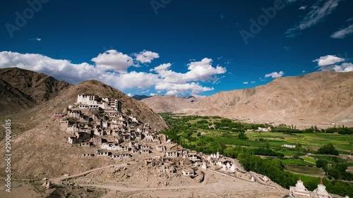 Chemdey Gompa overlooking Himalaya valley with lush green growth and vivid blue sky with fluffy cloud formations photo