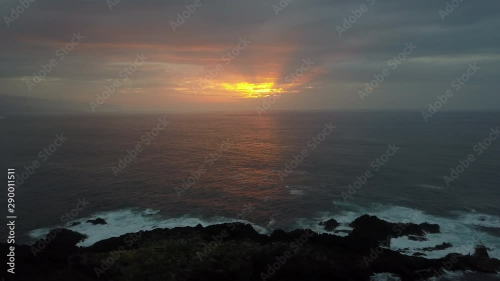 Side flight above ocean waves facing beautiful colourful sunset on Tenerife. Aerial drone shot of beautiful evening on the open sea, ocean. Side flight above ocean waves facing beautiful colourful sunset on Tenerife. Aerial drone shot of beautiful evening on the open sea, ocean.