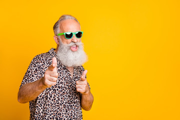 Portrait of funky old bearded man in eyeglasses eyewear feel cool crazy point at you wearing leopard shirt isolated over yellow background