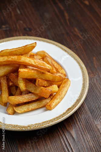 French fries on a white round plate. Restaurant menu