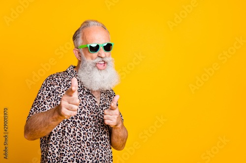 Portrait of funky old bearded man in eyeglasses eyewear feel cool crazy point at you wearing leopard shirt isolated over yellow background