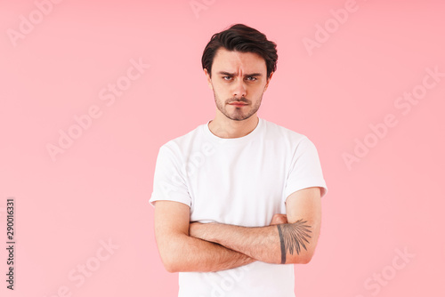 Image of caucasian perplexed man with bristle looking at camera with hands crossed