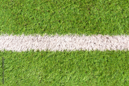 Artificial soccer field detail with a white line in the center