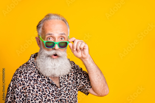 Close up photo of astonished man seeing something strange in front of him while isolated with yellow background photo