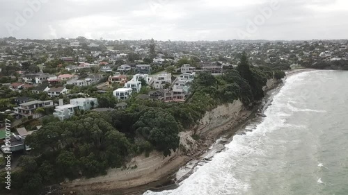 Aerial shot descending above Mairangi Bay coastline, Auckland, New Zealand photo