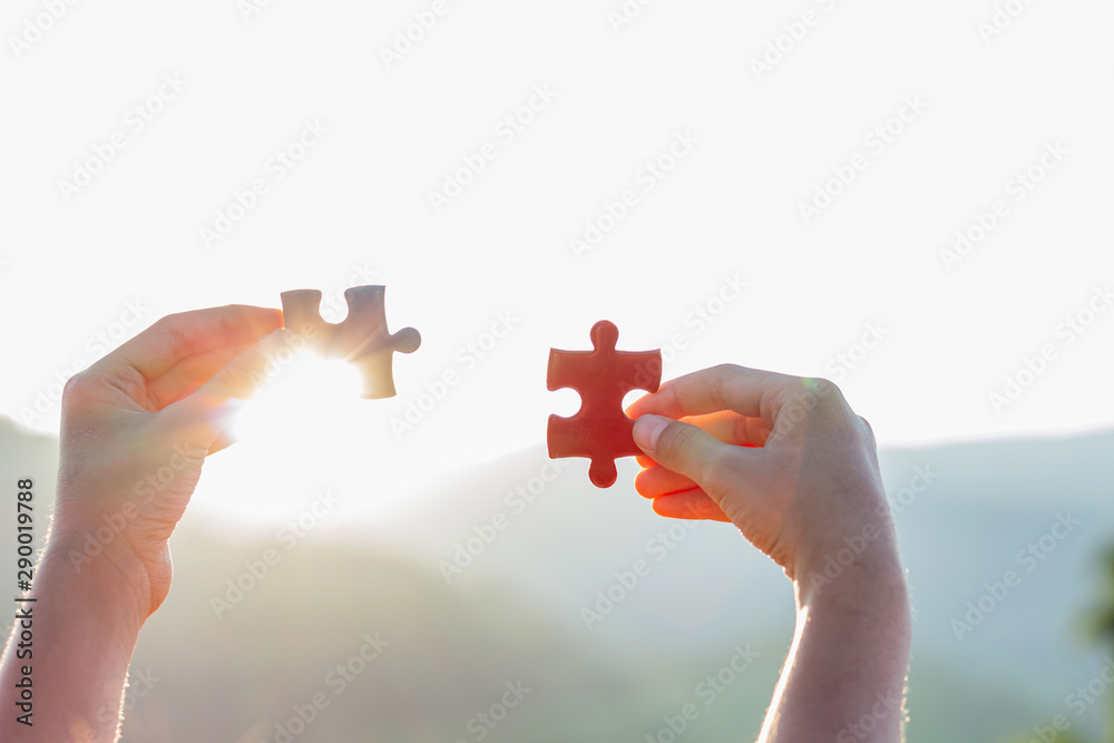 hands holding piece of red jigsaw puzzle. teamwork concept hands holding piece of red jigsaw puzzle. teamwork concept