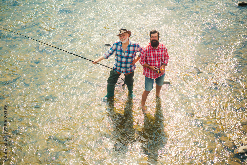 Fly fishing is most renowned as a method for catching trout grayling and salmon. Fisherman fishing with spinning reel. Angler. Generations men. Fly fishing is most renowned as a method for catching trout grayling and salmon. Fisherman fishing with spinning reel. Angler. Generations men.