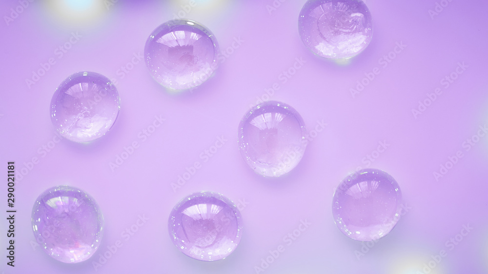 Abstract glass drops beads on a neon purple background