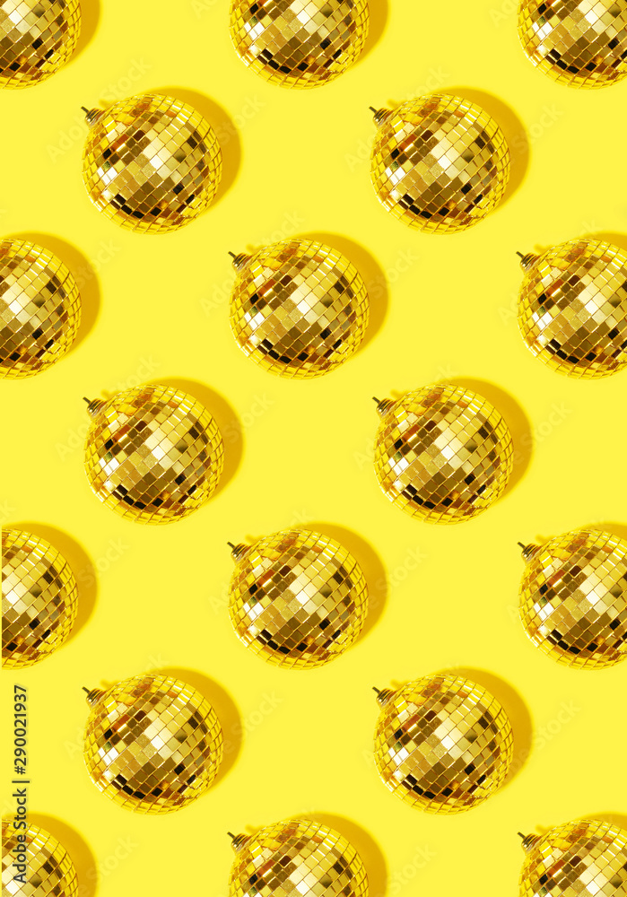 New year baubles. Shiny gold disco balls on yellow background. Pop disco style attributes, retro concept. Creative Christmas pattern. Flat lay, top view.