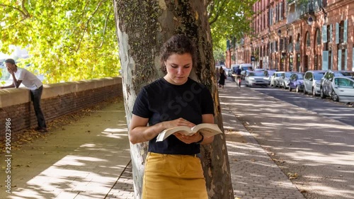 timelapse of a young woman reading in the street 