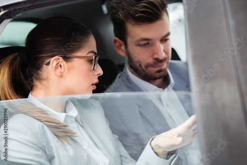 Young business people working together while traveling by a car.