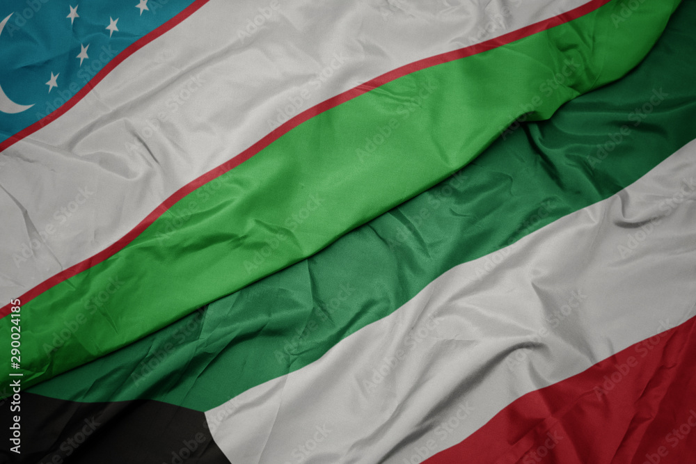 waving colorful flag of kuwait and national flag of uzbekistan.