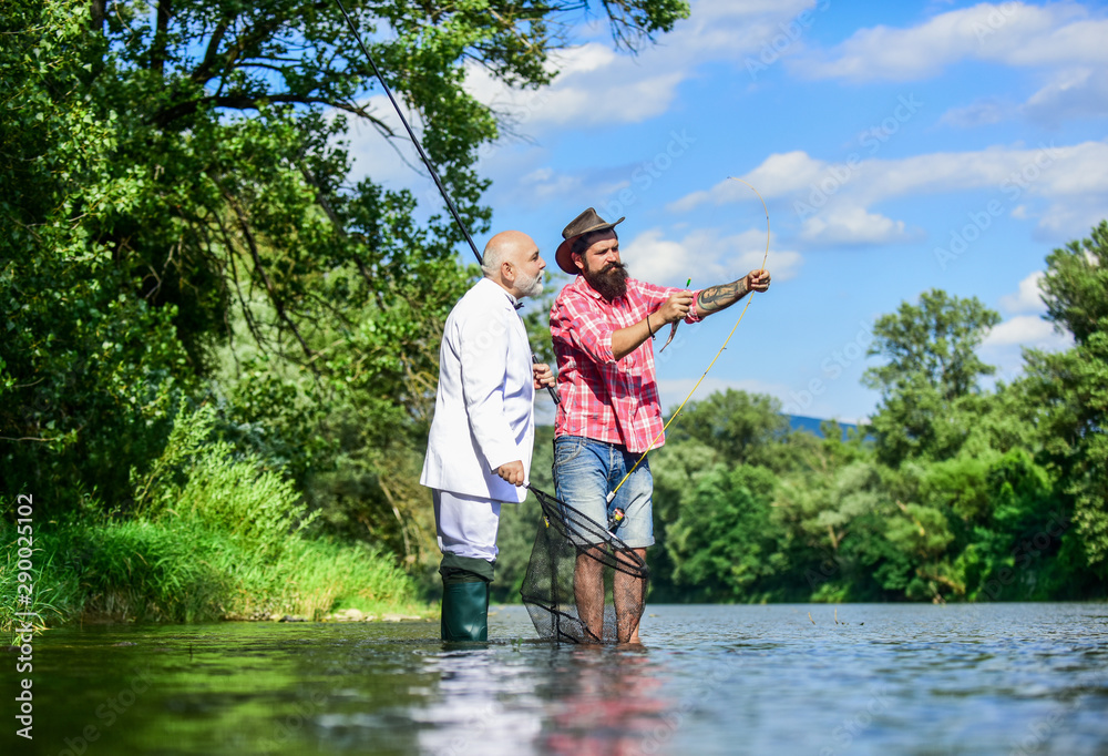 Preparation before fishing. Fly fishing adventures. retired father and mature son with beard. happy fishermen in water. friends men with fishing rod and net. hobby of businessman. retirement fishery Preparation before fishing. Fly fishing adventures. retired father and mature son with beard. happy fishermen in water. friends men with fishing rod and net. hobby of businessman. retirement fishery