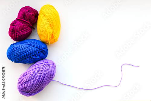 Balls of thread for knitting. Knitting threads on a white background. Materials to do the work at home. Multi-colored balls of thread for needlework. Copy space